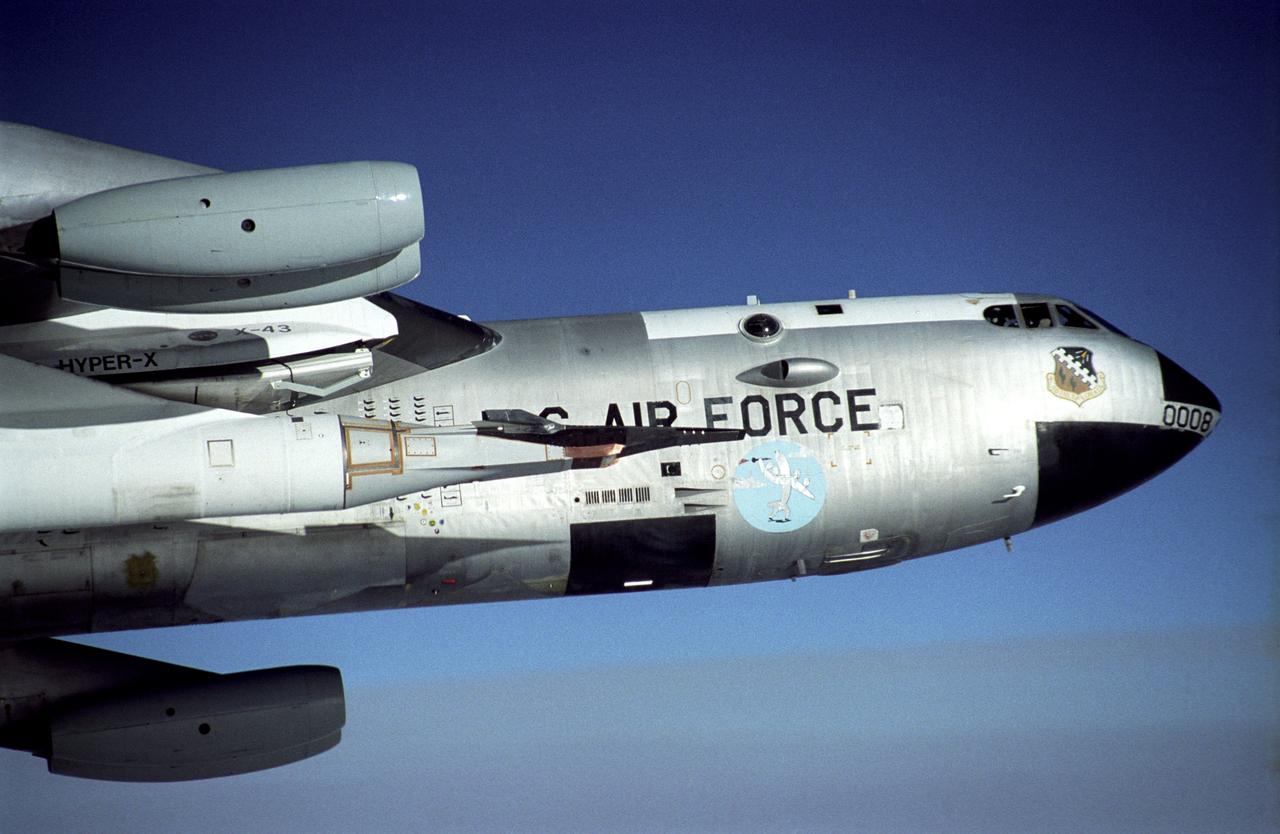 The black X-43A rides on the front of a modified Pegasus booster rocket hung from the special pylon under the wing of NASA's B-52B mother ship. The photo was taken during a captive carry flight Jan. 26, 2004 to verify systems before an upcoming launch.