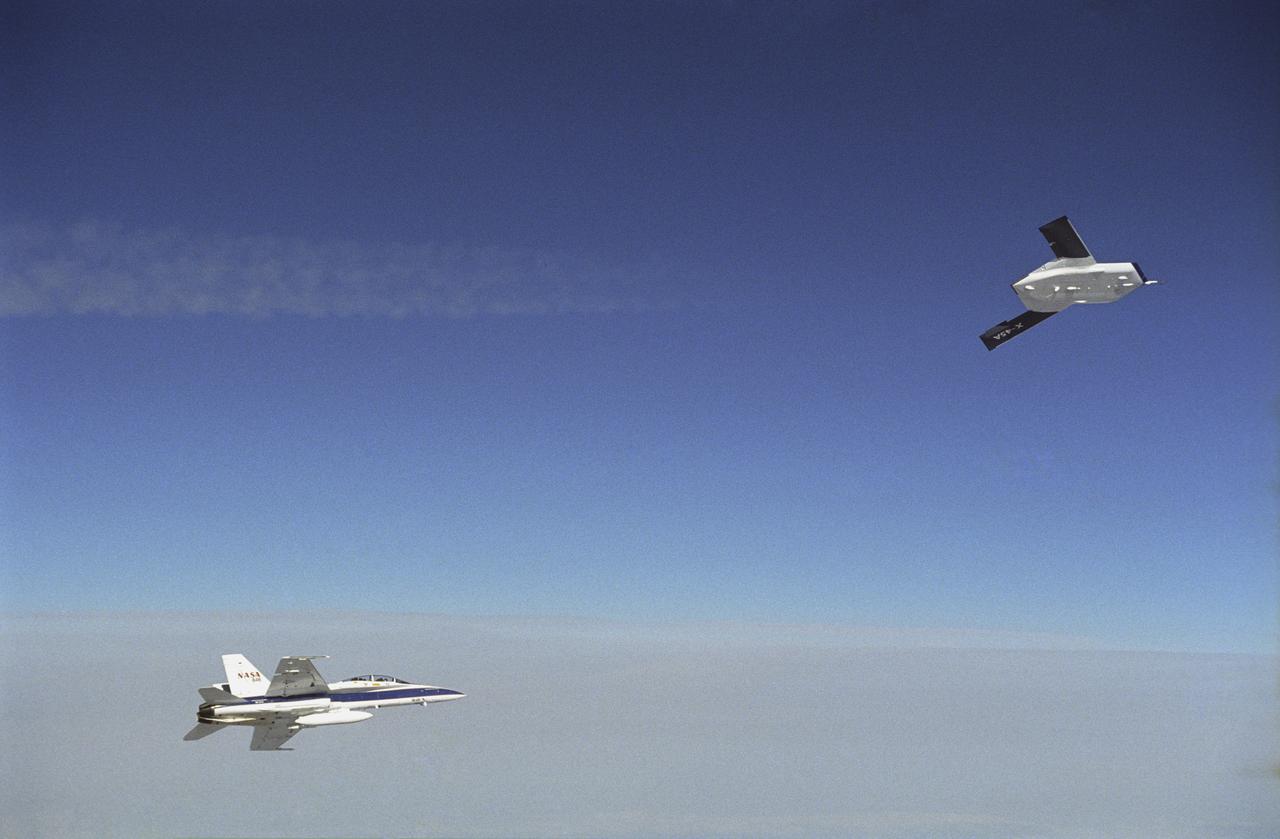 X-45A in flight with F-18 #846 chase aircraft, during first GPS-guided weapon demonstration flight.