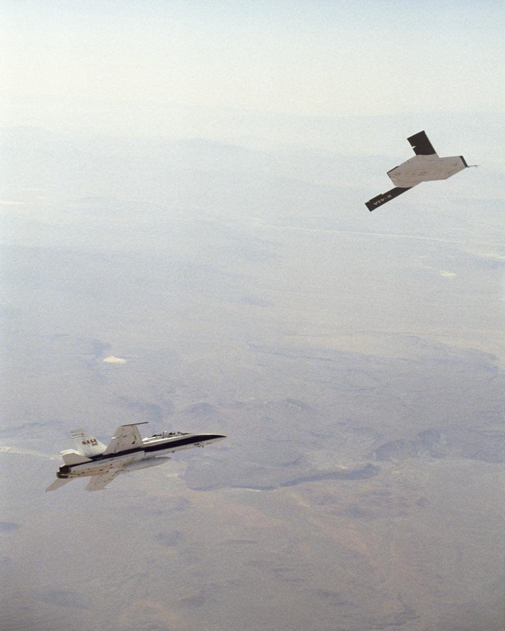 X-45A in flight with F-18 #846 chase aircraft, during first GPS-guided weapon demonstration flight.