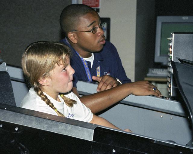 Nicole Schultheiss flies an F/A-18 simulator with NASA engineer Byron Simpson's coaching during Take Your Children to Work Day June 22
