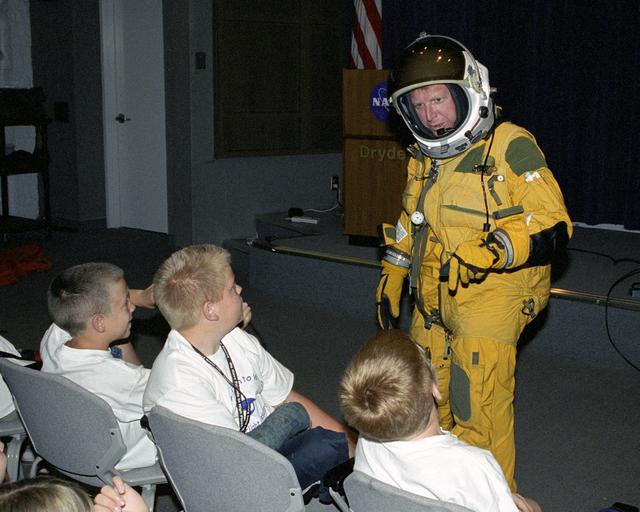 Dryden historian Christian Gelzer explains functions of a high-altitude pressure suit to (left to right) Brandon Blankenship, Garrett Clay and Eddie Patterson