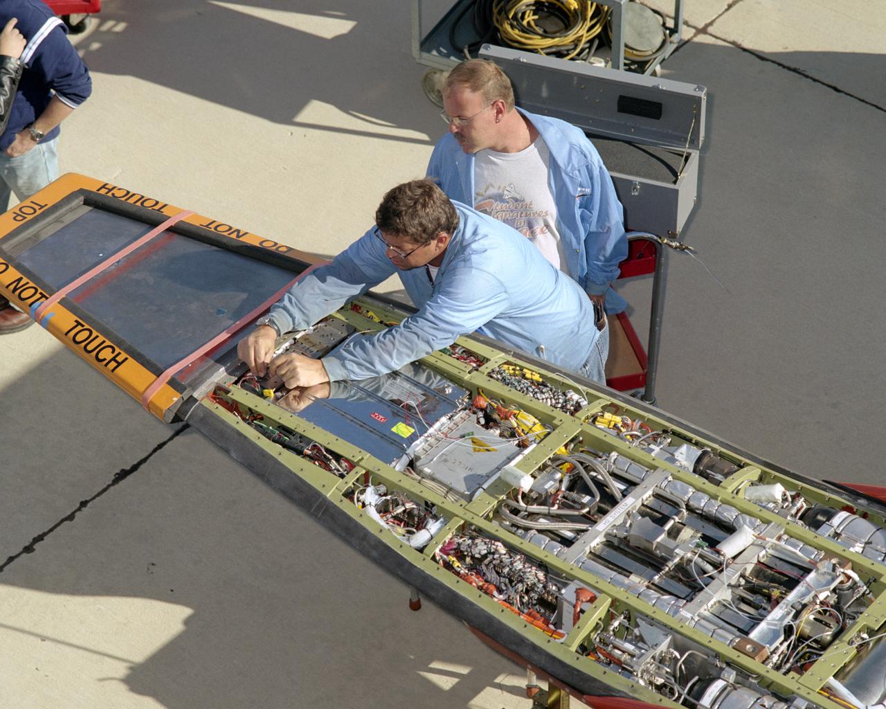 NASA avionics technicians Randy Wagner and Terry Bishop make final adjustments on the scramjet-powered X-43A before its record Mach 9.6 flight.