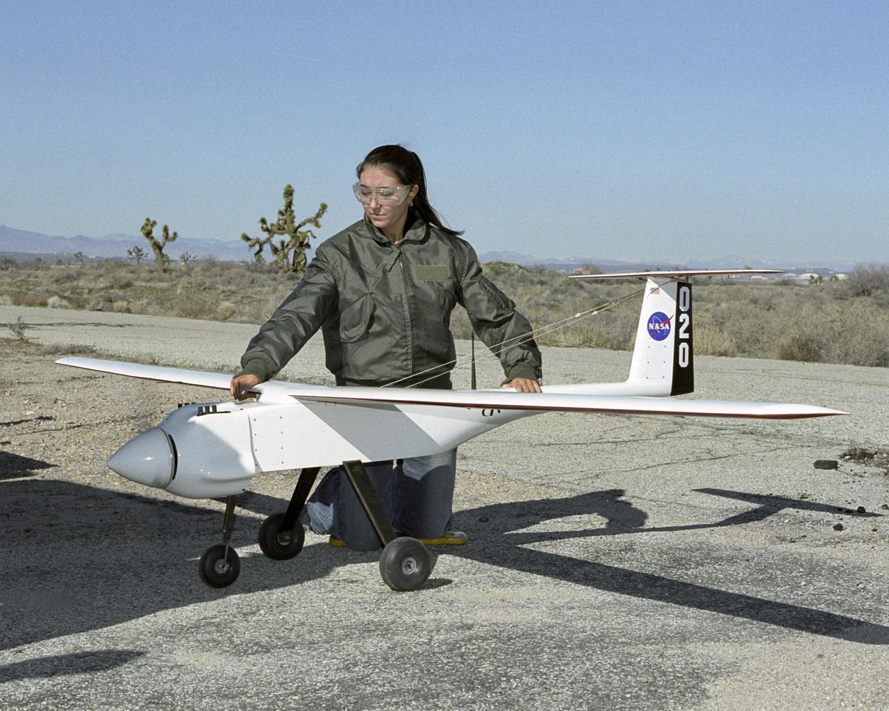 NASA Dryden Operations co-op student Shannon Kolensky holds one of the APV-3 UAVs flown in the Networked UAV Teaming Experiment steady during an engine runup.