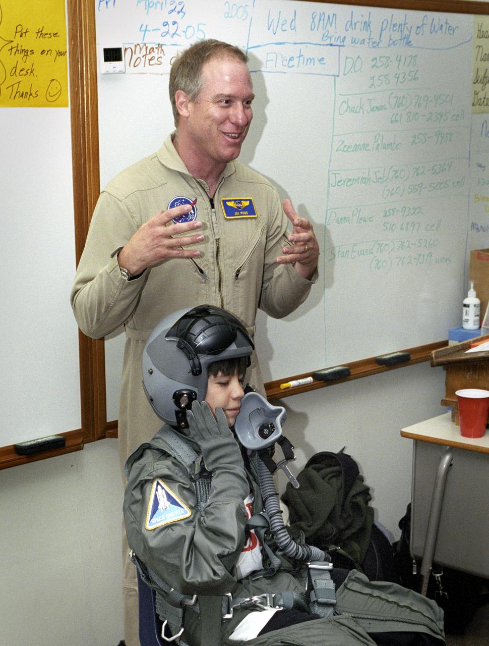 While NASA Dryden's Jim Ross outlined his job as an aerial photographer, sixth-grade student Leo Banuelos learned first-hand about the gear Ross wears in the cockpit.