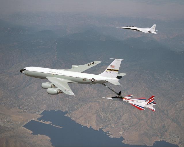 NASA image: One of NASA's two F-15 research aircraft gets refueled in mid-air over Lake Isabella from a USAF KC-135 tanker while NASA's other F-15 flies chase alongside.