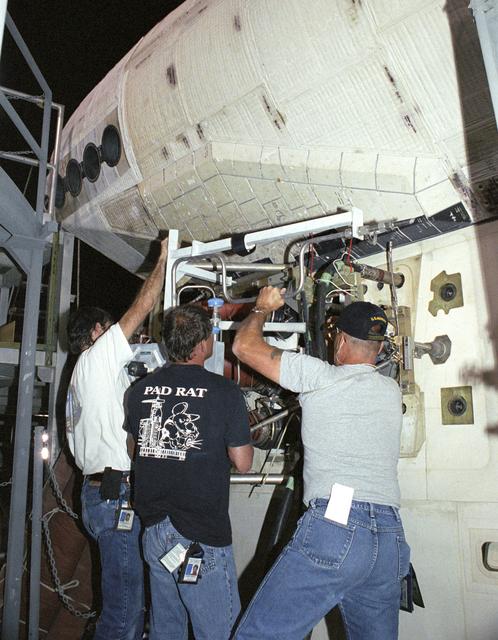 NASA image: Technicians Todd Viddle, Robert Garrett and Dan McGrath remove a servicing unit from the Space Shuttle Discovery during its post-flight processing at NASA DFRC