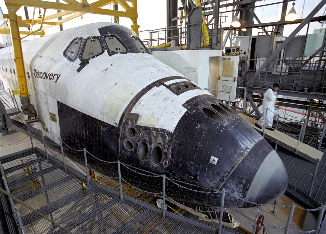 A technician leaves the 'white room', the access point for entering the Space Shuttle Discovery during post-flight processing in the Mate-Demate Device (MDD) at NASA's Dryden Flight Research Center in California. The gantry-like MDD structure is used for servicing the shuttle orbiters in preparation for their ferry flight back to the Kennedy Space Center in Florida, including mounting the shuttle atop NASA's modified Boeing 747 Shuttle Carrier Aircraft.  Space Shuttle Discovery landed safely at NASA's Dryden Flight Research Center at Edwards Air Force Base in California at 5:11:22 a.m. PDT, August 9, 2005, following the very successful 14-day STS-114 return to flight mission.  During their two weeks in space, Commander Eileen Collins and her six crewmates tested out new safety procedures and delivered supplies and equipment the International Space Station.  Discovery spent two weeks in space, where the crew demonstrated new methods to inspect and repair the Shuttle in orbit. The crew also delivered supplies, outfitted and performed maintenance on the International Space Station. A number of these tasks were conducted during three spacewalks.  In an unprecedented event, spacewalkers were called upon to remove protruding gap fillers from the heat shield on Discovery's underbelly. In other spacewalk activities, astronauts installed an external platform onto the Station's Quest Airlock and replaced one of the orbital outpost's Control Moment Gyroscopes.  Inside the Station, the STS-114 crew conducted joint operations with the Expedition 11 crew. They unloaded fresh supplies from the Shuttle and the Raffaello Multi-Purpose Logistics Module. Before Discovery undocked, the crews filled Raffeallo with unneeded items and returned to Shuttle payload bay.  Discovery launched on July 26 and spent almost 14 days on orbit.