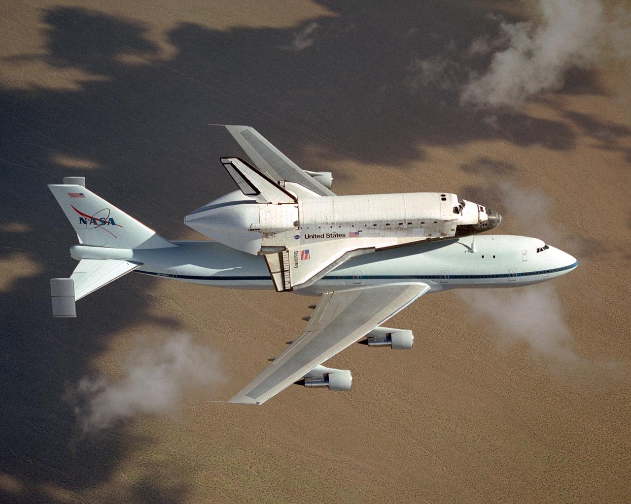 The space shuttle Discovery atop NASA's modified 747 is captured over the Mojave Desert while being ferried from NASA Dryden to the Kennedy Space Center. NASA's modified Boeing 747 Shuttle Carrier Aircraft with the Space Shuttle Discovery on top lifts off from Edwards Air Force Base to begin its ferry flight back to the Kennedy Space Center in Florida. The cross-country journey will take two days, with stops at several intermediate points for refueling.  Space shuttle Discovery landed safely at NASA's Dryden Flight Research Center at Edwards Air Force Base in California at 5:11:22 a.m. PDT, August 9, 2005, following the very successful 14-day STS-114 return to flight mission.  During their two weeks in space, Commander Eileen Collins and her six crewmates tested out new safety procedures and delivered supplies and equipment the International Space Station.  Discovery spent two weeks in space, where the crew demonstrated new methods to inspect and repair the Shuttle in orbit. The crew also delivered supplies, outfitted and performed maintenance on the International Space Station. A number of these tasks were conducted during three spacewalks.  In an unprecedented event, spacewalkers were called upon to remove protruding gap fillers from the heat shield on Discovery's underbelly. In other spacewalk activities, astronauts installed an external platform onto the Station's Quest Airlock and replaced one of the orbital outpost's Control Moment Gyroscopes.  Inside the Station, the STS-114 crew conducted joint operations with the Expedition 11 crew. They unloaded fresh supplies from the Shuttle and the Raffaello Multi-Purpose Logistics Module. Before Discovery undocked, the crews filled Raffeallo with unneeded items and returned to Shuttle payload bay.  Discovery launched on July 26 and spent almost 14 days on orbit.
