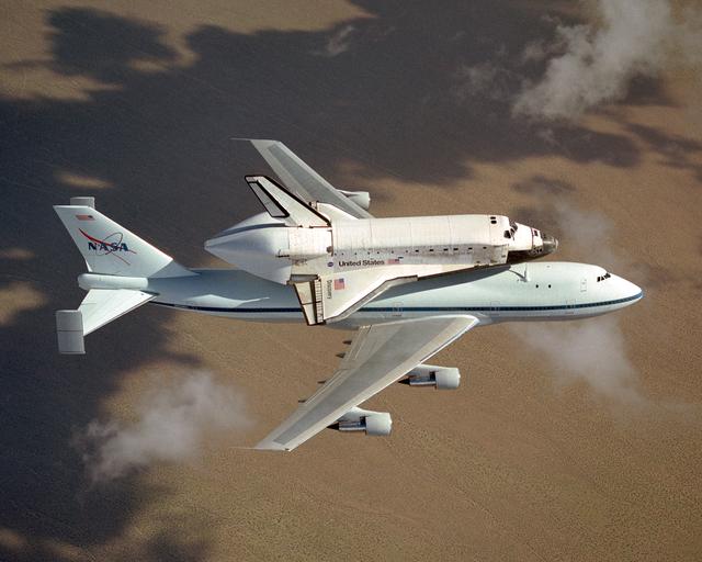 NASA image: The space shuttle Discovery atop NASA's modified 747 is captured over the Mojave Desert while being ferried from NASA Dryden to the Kennedy Space Center