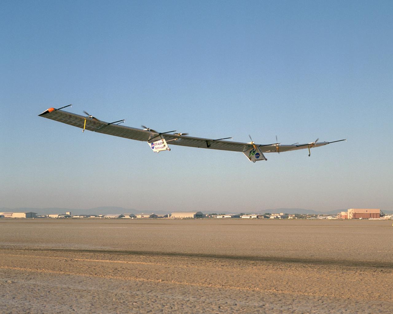 With turbulence-measurement booms projecting ahead of the wing, Pathfinder-Plus soars aloft over Rogers Dry Lake on its final research flight from NASA Dryden.