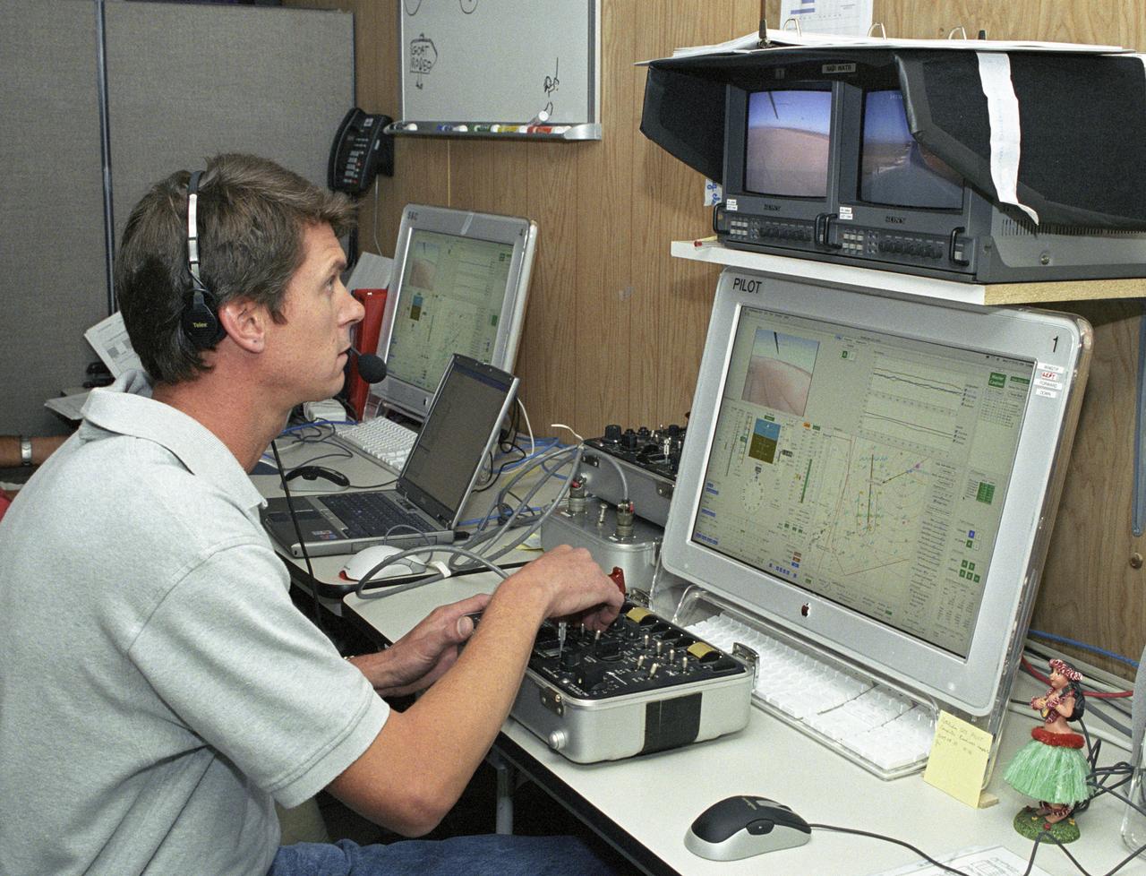 AeroVironment pilot Wyatt Sadler controls the Pathfinder-Plus flying wing from a small console, video and computer monitors in the ground station.