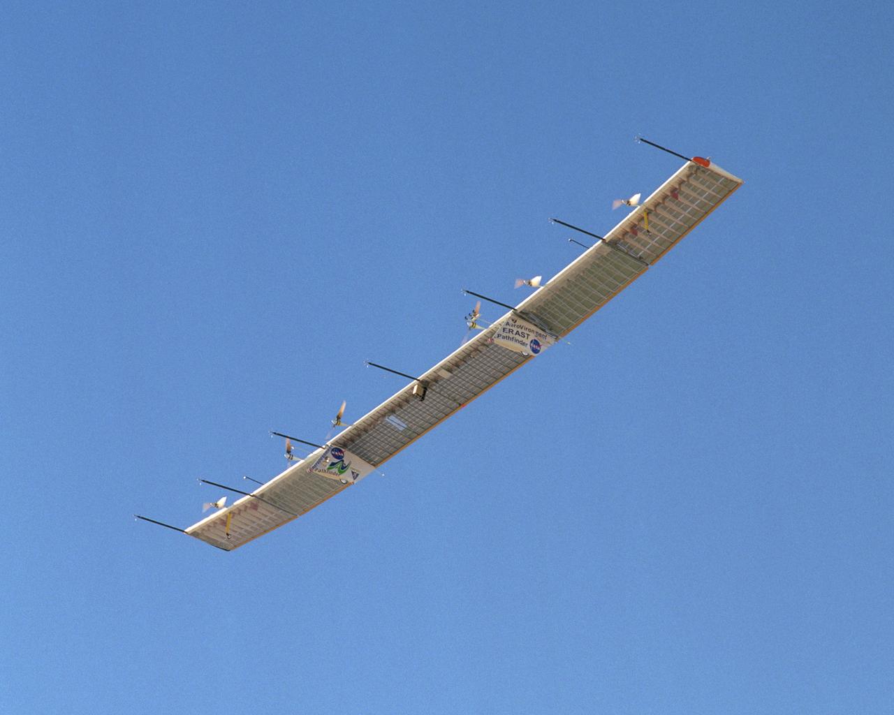 With its sensor booms projecting ahead of the wing, the Pathfinder-Plus solar-electric aircraft soars under a blue sky on a turbulence measurement research flight.