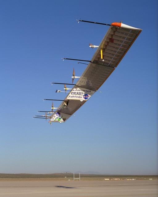 The Atmospheric Turbulence Measurement System booms extend forward from the Pathfinder-Plus solar wing as it soars over Rogers Dry Lake.