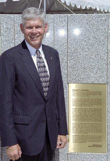 NASA image: Former NASA research pilot Eddie Schneider with the brass plaque summarizing his career during the 2005 Aerospace Walk of Honor ceremonies in Lancaster, Calif.