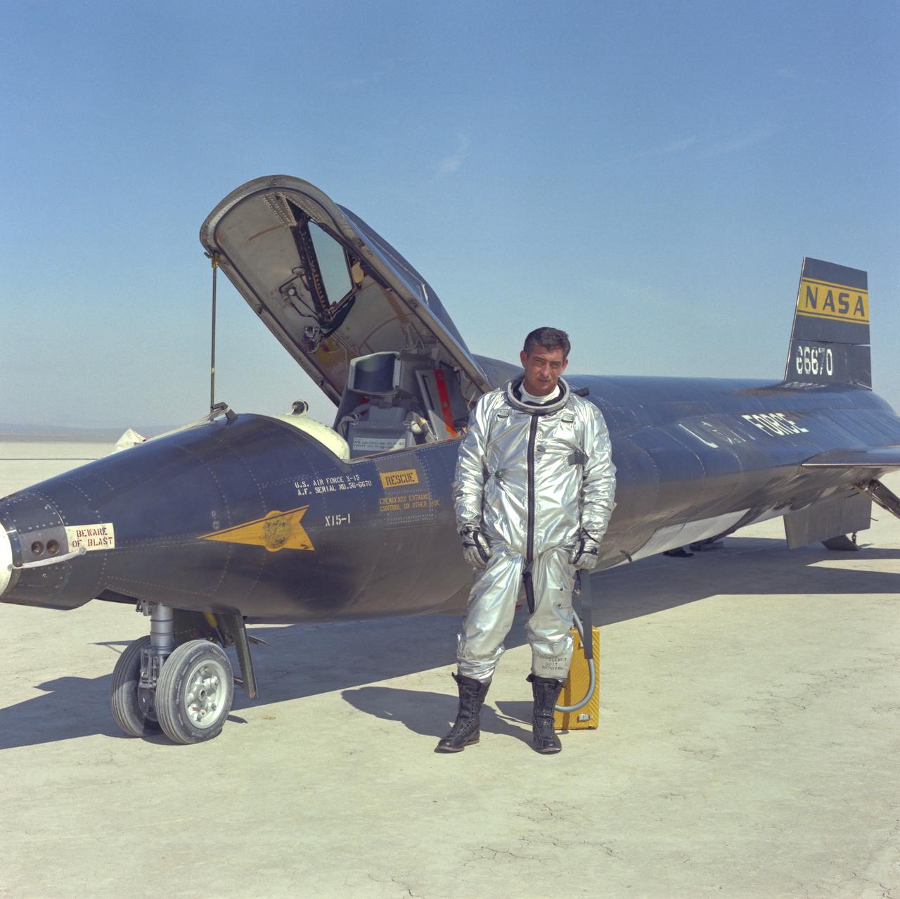 Air Force pilot Mike Adams poses in front of X-15-#1 after flight on Rogers Dry Lake at Edwards Air Force Base in California.
