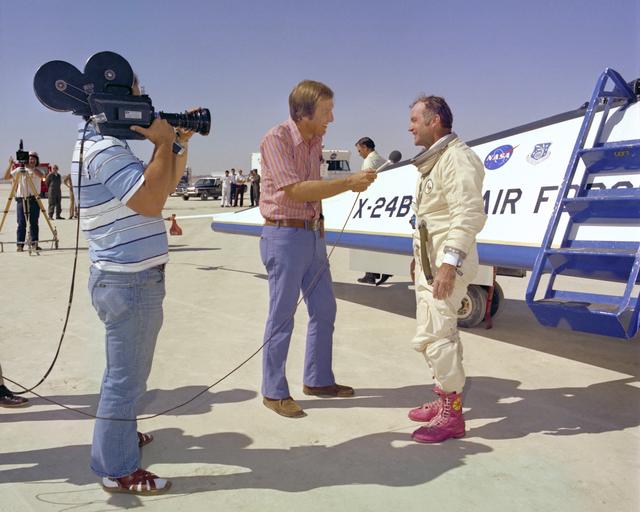 NASA image: A TV reporter interviews NASA test pilot Bill Dana, wearing his infamous pink boots with yellow daisy decals, after the last powered flight of the X-24B.