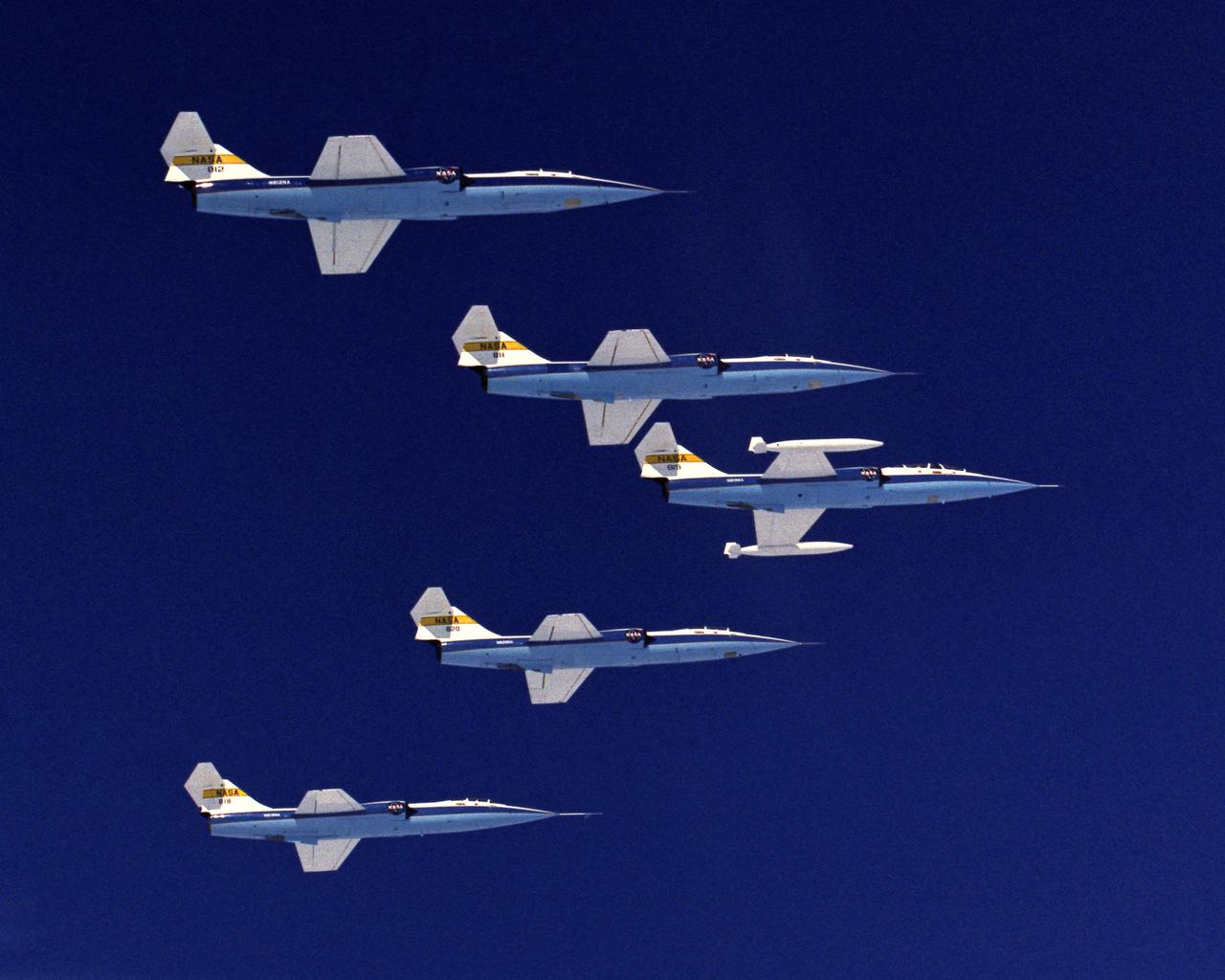 The only time the five ship fleet of F-104 Starfighters was ever airborne at the same time. Pilots were: F-104N #811-Bill Dana; F-104N #812-Tom McMurtry; F-104A #818-Einar Enevoldson; F-104A #820-Gary Krier; F-104B #819-Fitz Fulton and Ray Young. Photo taken from T-38 #821 flown by Don Mallick and photographer was Bob Rhine. 4/11/75 NASA DFRC EC76-5145