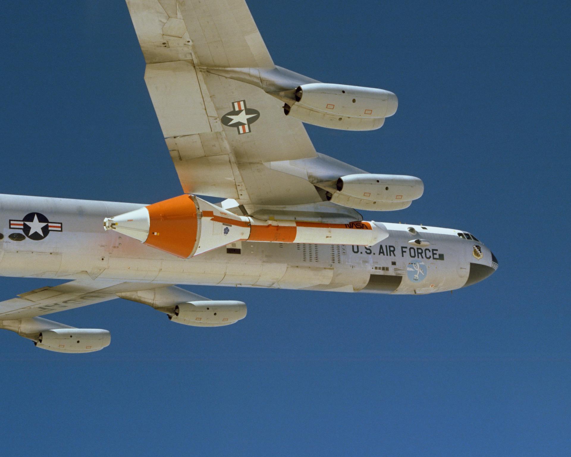 B-52B aircraft in flight carrying the Space Shuttle Solid Rocket Booster.