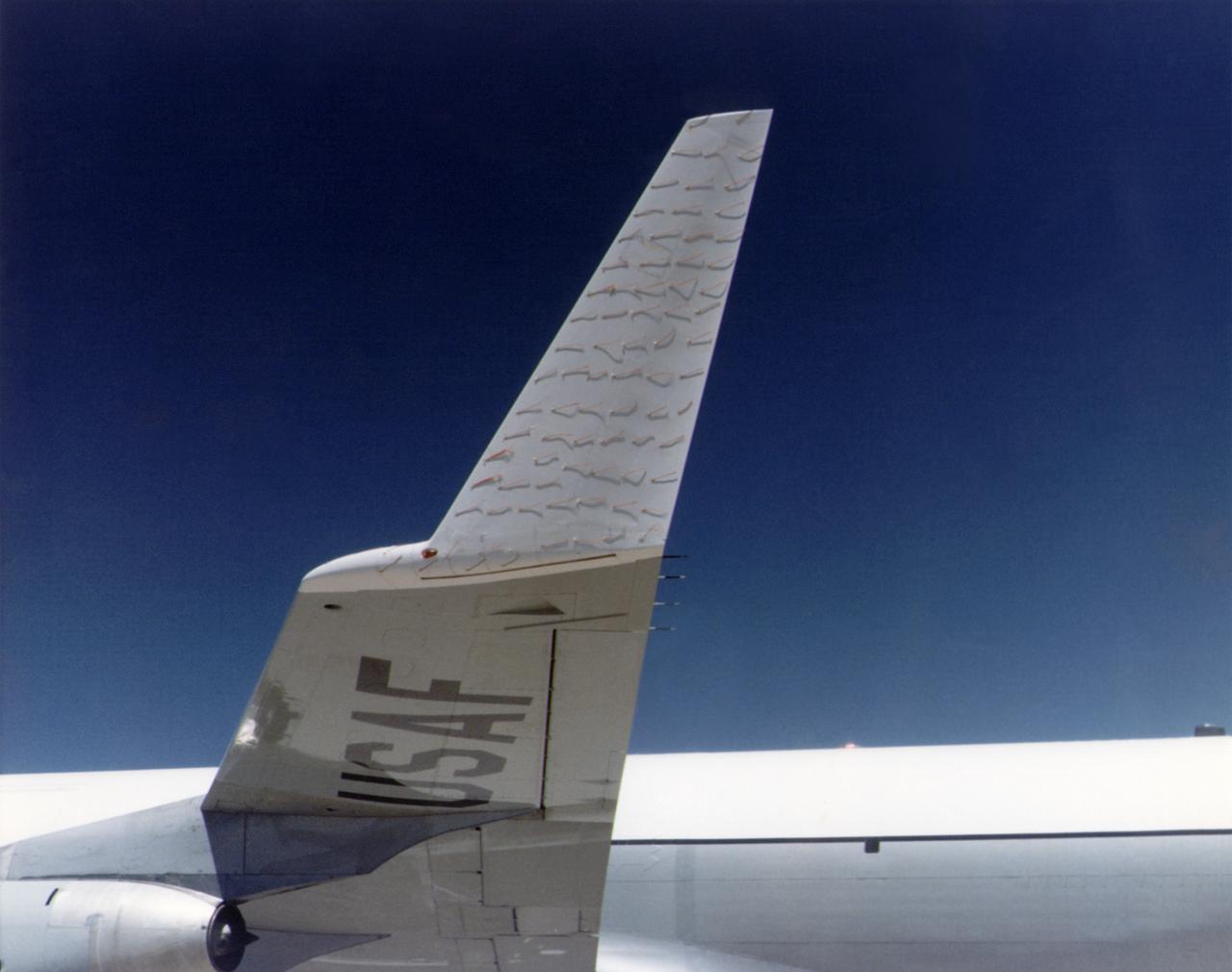 A chase plane view of the tufts on the KC-135 winglet. The use of tufts in flight research dates back to the early days of the NACA, and remains an effective means of observing airflow even today. In this procedure, rows of strings are attached to an airplane's surface, with one end of each string taped to the airplane and the other end free to swing about in the airflow. The movements of the tufts are photographed by on-board cameras or a chase plane. If the tufts are arrayed in neat rows, as seen here, then the airflow is smooth over the airplane's surface. If, however, they are moving about violently, it suggests turbulent airflow. Such motions may indicate high drag, flow separation (such as in a stall), or buffeting. In some cases, tufts will actually point forward, indicating the airflow has reversed direction.