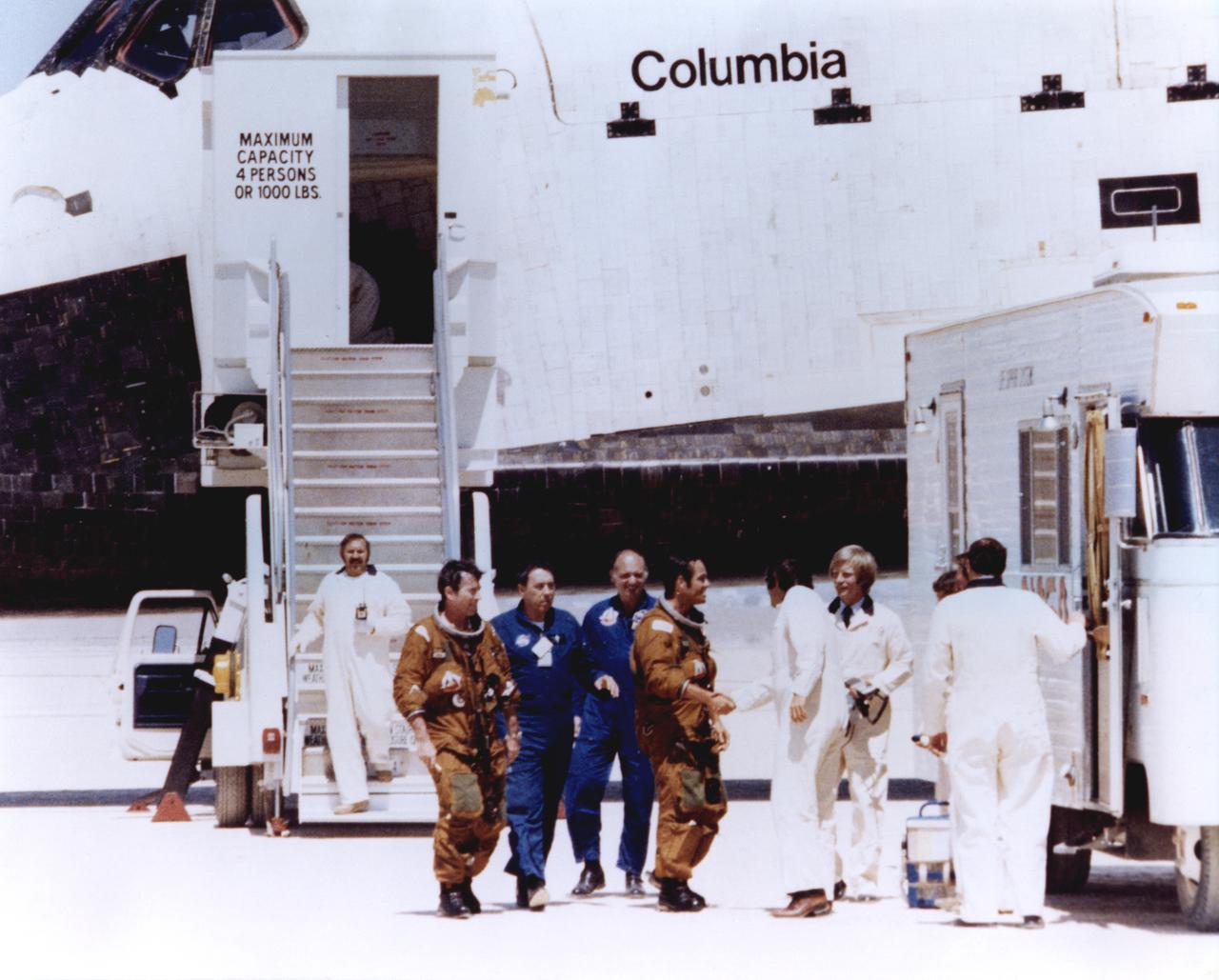WELCOME HOME -- Space Shuttle astronauts John Young and Robert Crippen (in tan space suits) are greeted by members of the ground crew moments after stepping off the shuttle Columbia following its first landing at Edwards Air Force Base, Calif. Young and Crippen had piloted the Columbia on its first orbital space mission, April 12 - 14, 1981.