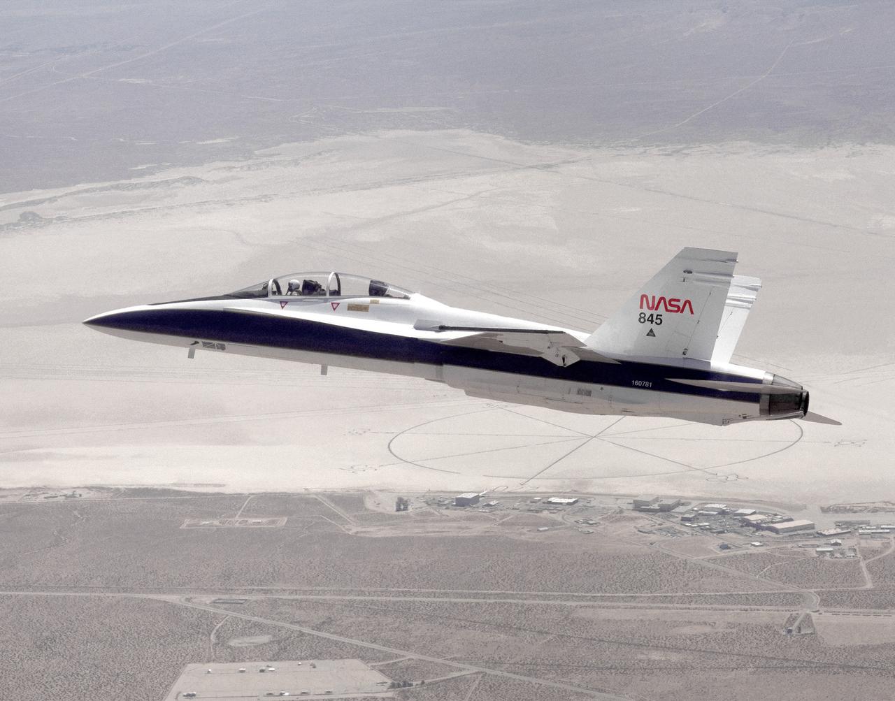 The National Aeronautics and Space Administration's Systems Research Aircraft (SRA), a highly modified F-18 jet fighter, on an early research flight over Rogers Dry Lake. The former Navy aircraft was flown by NASA's Dryden Flight Research Center at Edwards Air Force Base, California, to evaluate a number of experimental aerospace technologies in a multi-year, joint NASA/DOD/industry program. Among the more than 20 experiments flight-tested were several involving fiber optic sensor systems. Experiments developed by McDonnell-Douglas and Lockheed-Martin centered on installation and maintenace techniques for various types of fiber-optic hardware proposed for use in military and commercial aircraft, while a Parker-Hannifin experiment focused on alternative fiber-optic designs for postion measurement sensors as well as operational experience in handling optical sensor systems.  Other experiments flown on this testbed aircraft included electronically-controlled control surface actuators, flush air data collection systems, "smart" skin antennae and laser-based systems. Incorporation of one or more of these technologies in future aircraft and spacecraft could result in signifigant savings in weight, maintenance and overall cost.