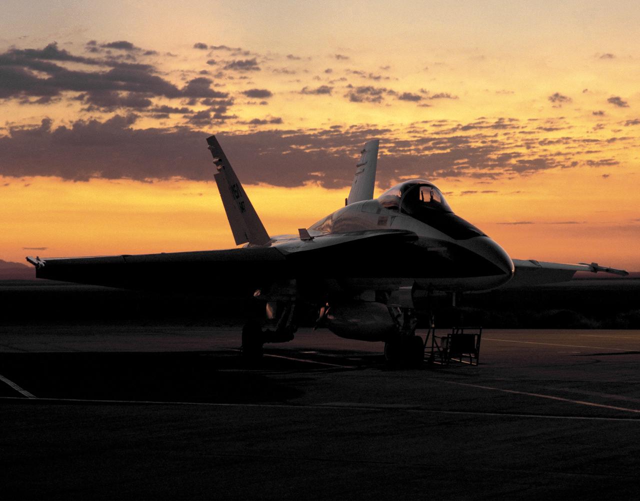 One of NASA's F/A-18 Hornets on the ramp at the Dryden Flight Research Center, Edwards, California at dawn August 6, 1993. F-18 aircraft, on loan to NASA by the U.S. Navy, were flown at Dryden as support aircraft and as research testbeds. As support aircraft, they were used primarily for safety chase, pilot proficiency and aerial photography. As research aircraft, they were involved in thrust vectoring and high angle of attack research, as well as numerous smaller scale experiments.