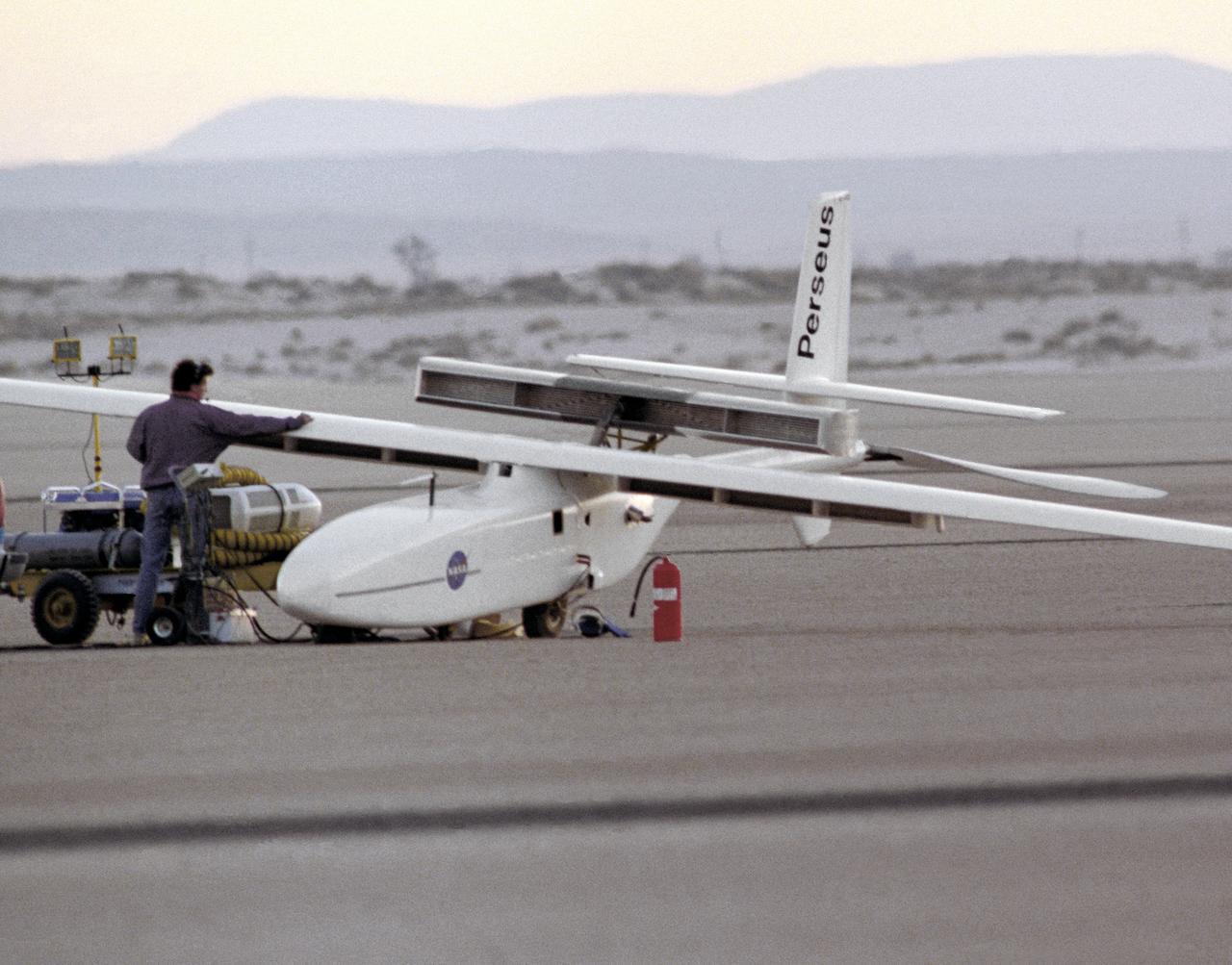 The Perseus A, a remotely-piloted, high-altitude research vehicle, is seen just after landing on Rogers Dry Lake at the Dryden Flight Research Center, Edwards, California. The Perseus A had a unique method of takeoff and landing. To make the aircraft as aerodynamic and lightweight as possible, designers gave it only two very small centerline wheels for landing. These wheels were very close to the fuselage, and therefore produced very little drag. However, since the fuselage sat so close to the ground, it was necessary to keep the large propeller at the rear of the aircraft locked in a horizontal position during takeoff. The aircraft was towed to about 700 feet in the air, where the engine was started and the aircraft began flying under its own power.
