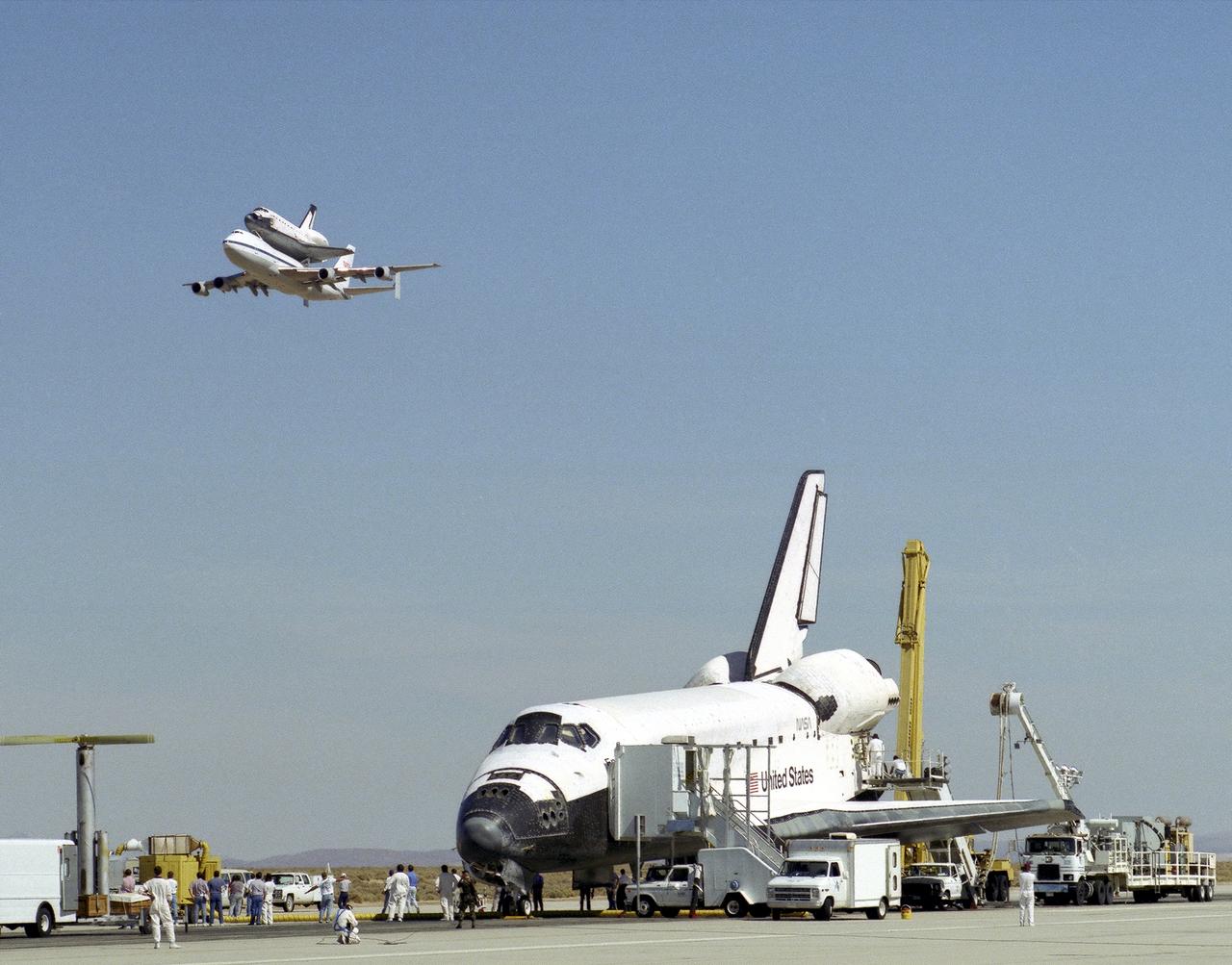 The space shuttle Endeavour receives a high-flying salute from its sister shuttle, Columbia, atop NASA's Shuttle Carrier Aircraft, shortly after Endeavor’s landing 11 October 1994, at Edwards, California, to complete mission STS-68. Columbia was being ferried from the Kennedy Space Center, Florida, to Air Force Plant 42, Palmdale, California, where it will undergo six months of inspections, modifications, and systems upgrades. The STS-68 11-day mission was devoted to radar imaging of Earth's geological features with the Space Radar Laboratory. The orbiter is surrounded by equipment and personnel that make up the ground support convoy that services the space vehicles as soon as they land.