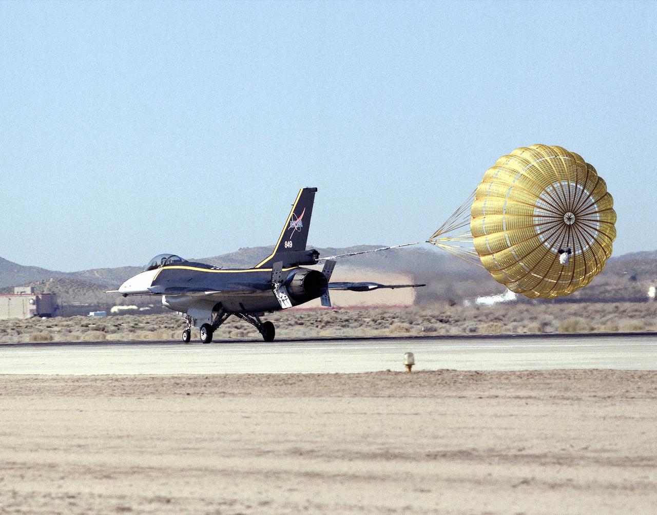 NASA's single-seat F-16XL makes a drag chute landing on the runway at Edwards Air Force Base in California's Mojave Desert. The aircraft was most recently used in the Cranked-Arrow Wing Aerodynamics Project (CAWAP) to test boundary layer pressures and distribution. Previously it had been used in a program to investigate the characteristics of sonic booms for NASA's High Speed Research Program. Data from the program will be used in the development of a high speed civilian transport. During the series of sonic boom research flights, the F-16XL was used to probe the shock waves being generated by a NASA SR-71 and record their shape and intensity.