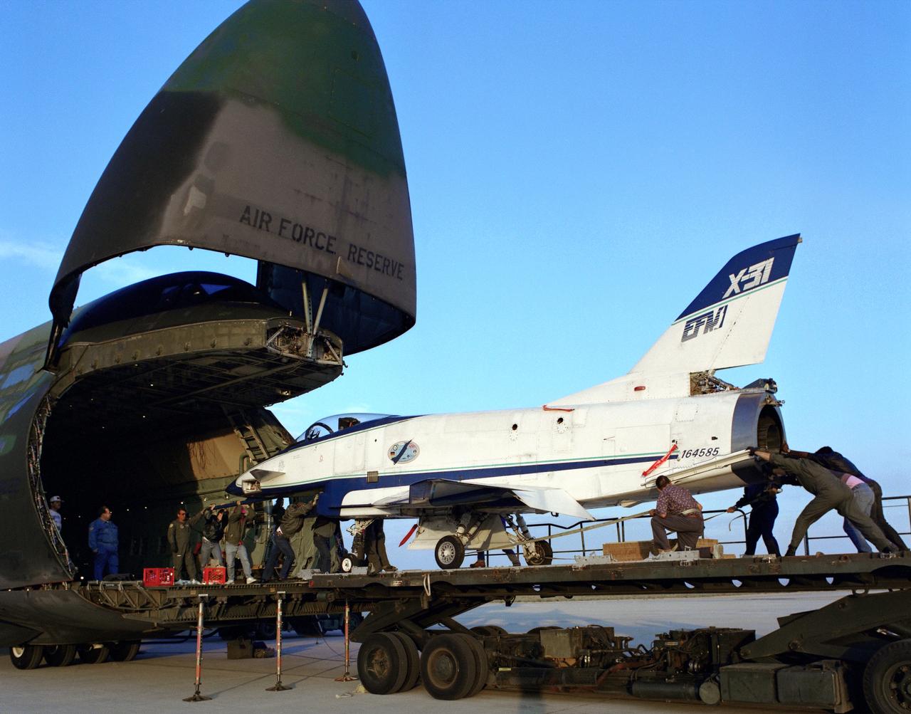 The X-31 Enhanced Fighter Maneuverability Technology Demonstrator Aircraft, based at the NASA Dryden Flight Research Center, Edwards, California, begins rolling aboard an Air Force Reserve C-5 transport which ferried it on May 22, 1995 to Europe where it was flown in the Paris Air Show in June 1995. To fit in the C-5 the right wing of the X-31 had to be removed. At the air show, the X-31 demonstrated the value of using thrust vectoring (directing engine exhaust flow) coupled with advanced flight control systems to provide controlled flight at very high angles of attack.
