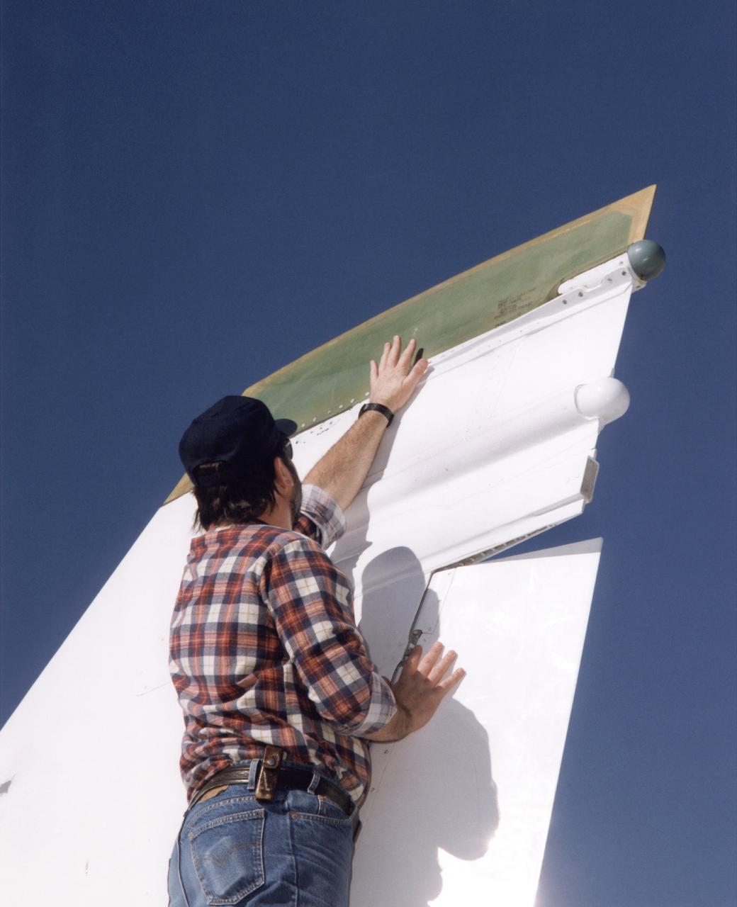 Bob Cummings, a technician at NASA's Dryden Flight Research Center, Edwards, California, checks out a new "Smart Skin" antenna mounted on the tip of the right vertical fin of Dryden's F/A-18 Systems Research Aircraft. Flight tests of the antenna system demonstrated a five-fold increase in voice communications range and a substantial improvement in the pattern of radiation and quality of transmission compared to the standard dorsal blade antenna on the aircraft. The Smart Skin antenna system was electrically as well as physically connected to the airframe, making the aircraft skin operate as an antenna along with the antenna itself. The concept was developed by TRW Avionics Systems Division and integrated into the F/A-18's vertical fin by Northrop-Grumman Corporation.
