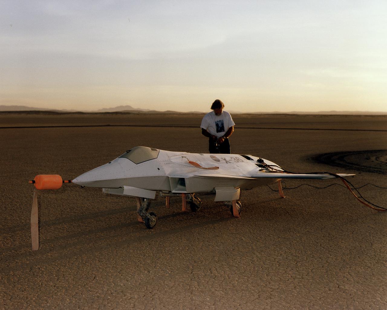 Lit by the rays of the morning sunrise on Rogers Dry Lake, adjacent to NASA's Dryden Flight Research Center, Edwards, California, a technician prepares the remotely-piloted X-36 Tailless Fighter Agility Research Aircraft for its first flight on May 17, 1997.