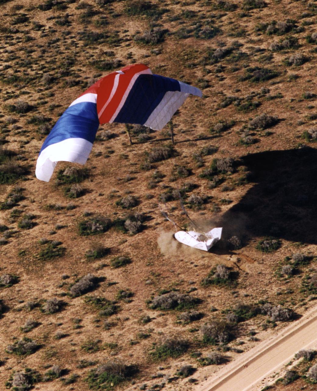 The X-38 Crew Return Vehicle touches down amidst the California desert scrubbrush at the end of its first free flight at the Dryden Flight Research Center, Edwards, California, in March 1998.