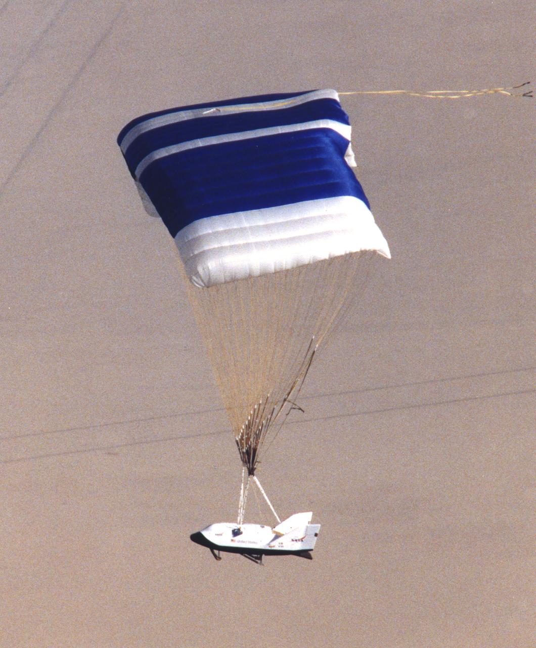 NASA's X-38, a research vehicle developed as part of an effort to build an emergency Crew Return Vehicle (CRV) for the International Space Station, descends toward a desert lakebed under its steerable parafoil on its second free flight. The X-38 was launched from NASA Dryden's B-52 Mothership on Saturday, February 6, 1999, from an altitude of approximately 23,000 feet.