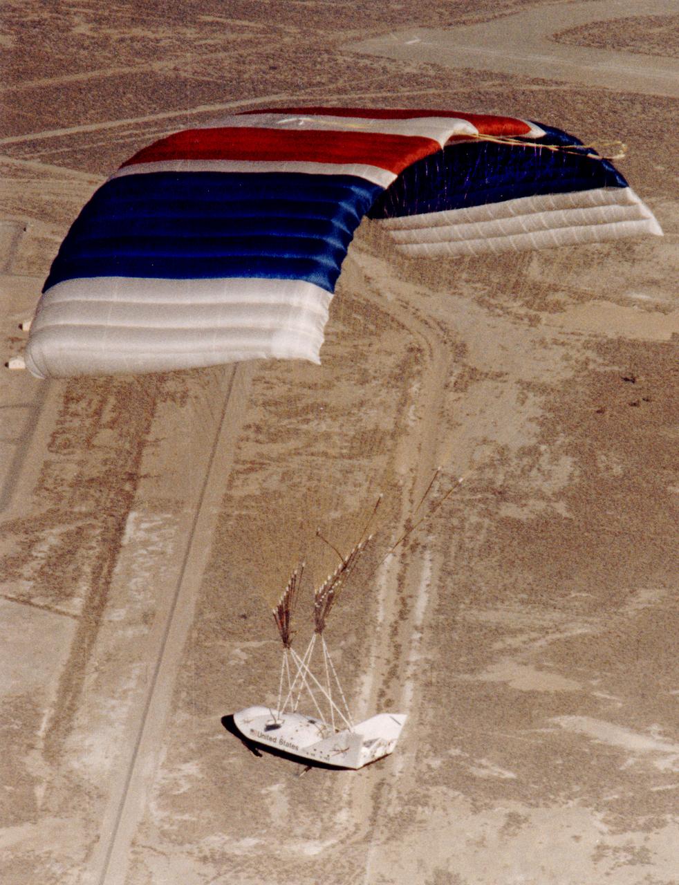 The X-38, a research vehicle built to help develop technology for an emergency Crew Return Vehicle (CRV), descends under its steerable parafoil on a March 1999 test flight at the Dryden Flight Research Center, Edwards, California.
