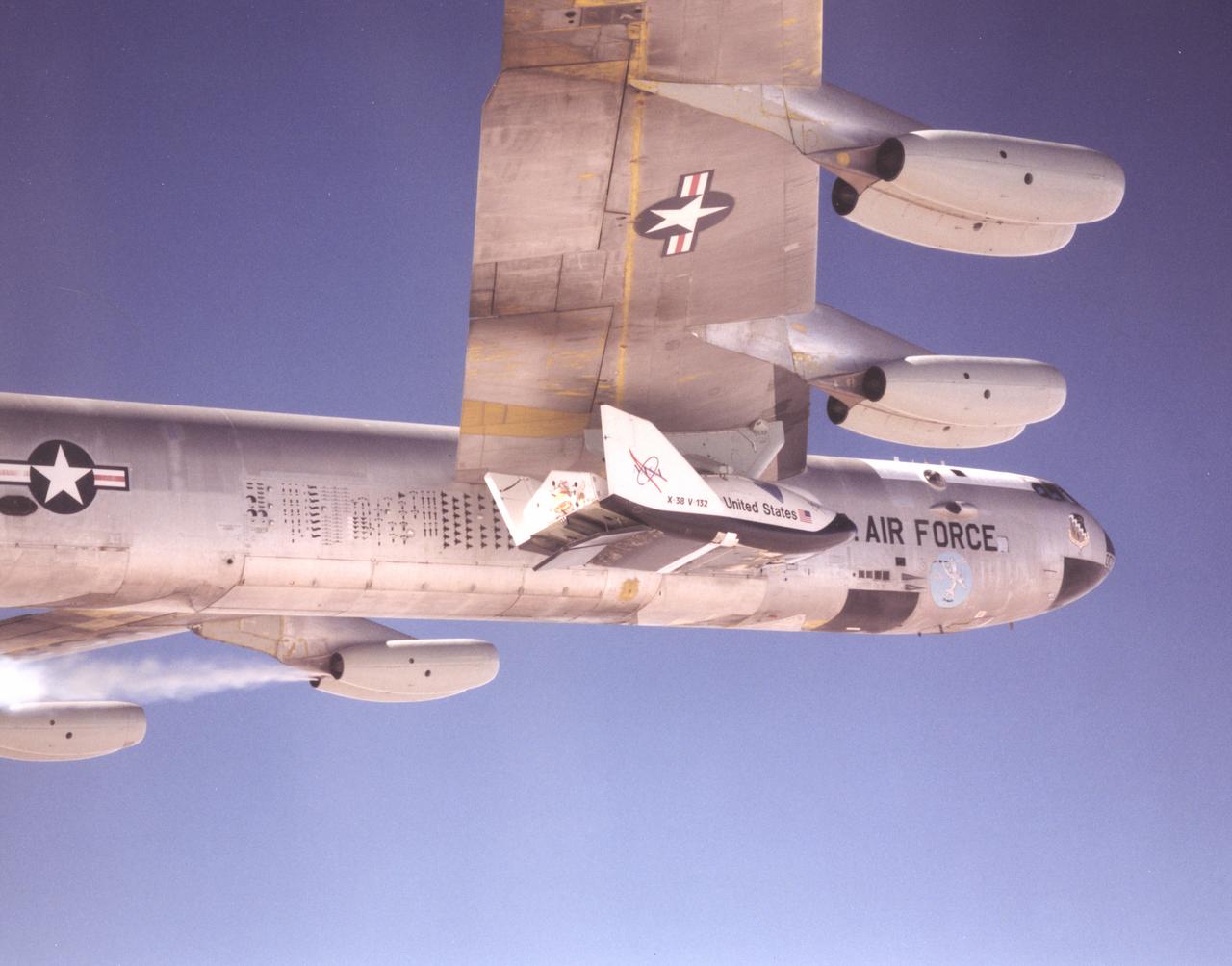 This photo shows one of the X-38 lifting-body research vehicles mated to NASA's B-52 mothership in flight prior to launch. The B-52 has been a workhorse for the Dryden Flight Research Center for more than 40 years, carrying numerous research vehicles aloft and conducting a variety of other research flight experiments.