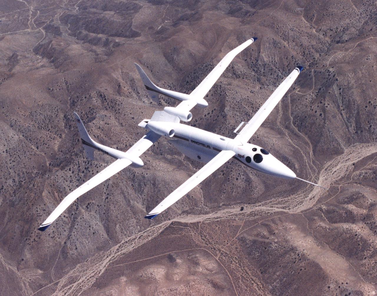 The unusual design of the Proteus high-altitude aircraft, incorporating a gull-wing shape for its main wing and a long, slender forward canard, is clearly visible in this view of the aircraft in flight over the Mojave Desert in California.