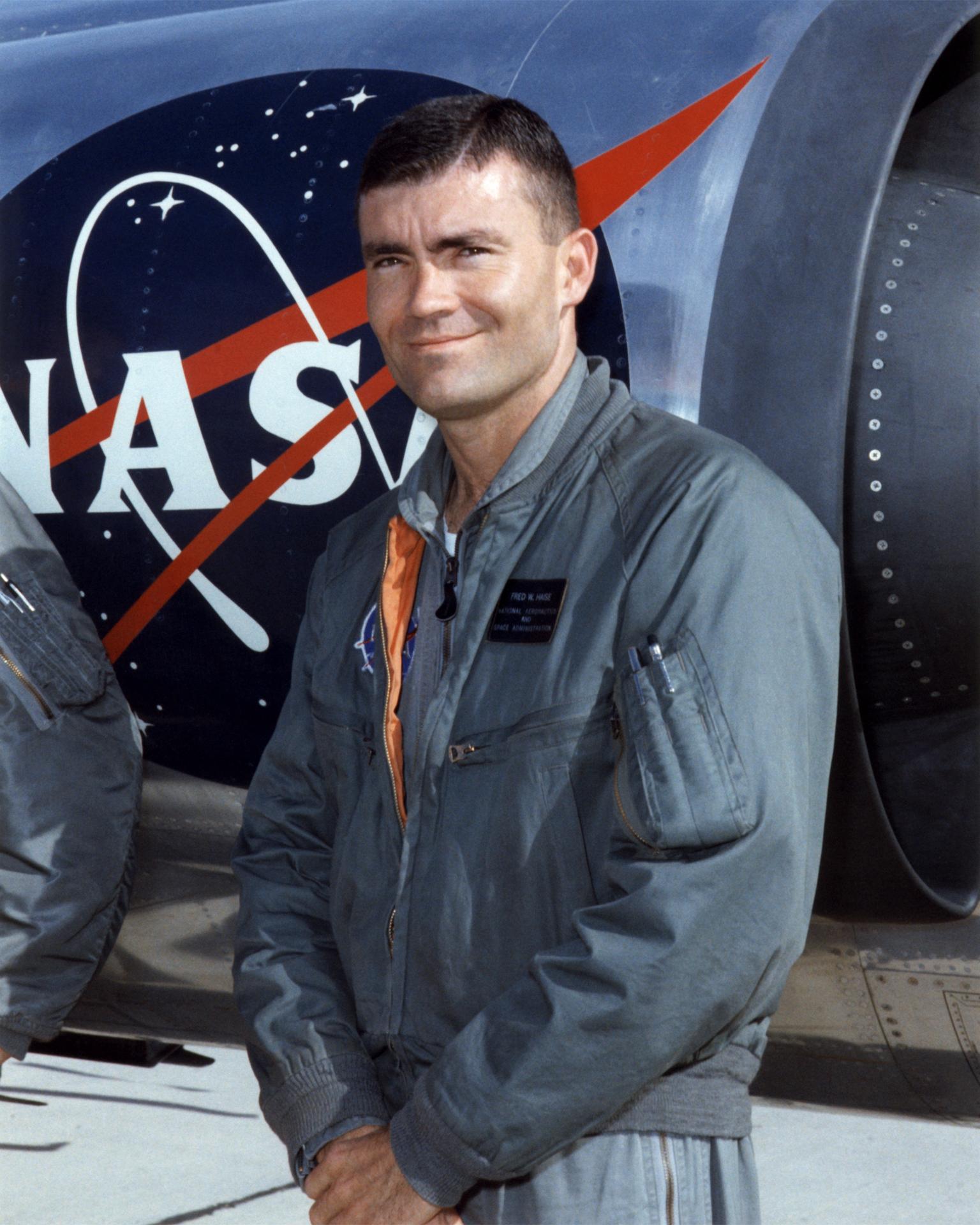 Man in bomber jacket posed in front of aircraft.