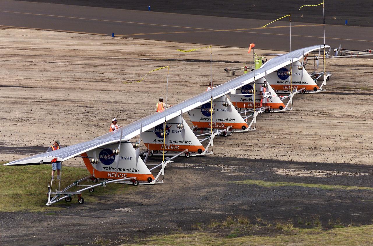 Ground crewmen maneuver AeroVironment's solar-powered Helios Prototype flying wing on its ground support dolly during functional checkouts prior to its first flights under solar power from the U.S. Navy's Pacific Missile Range Facility on Kaua'i, Hawaii.
