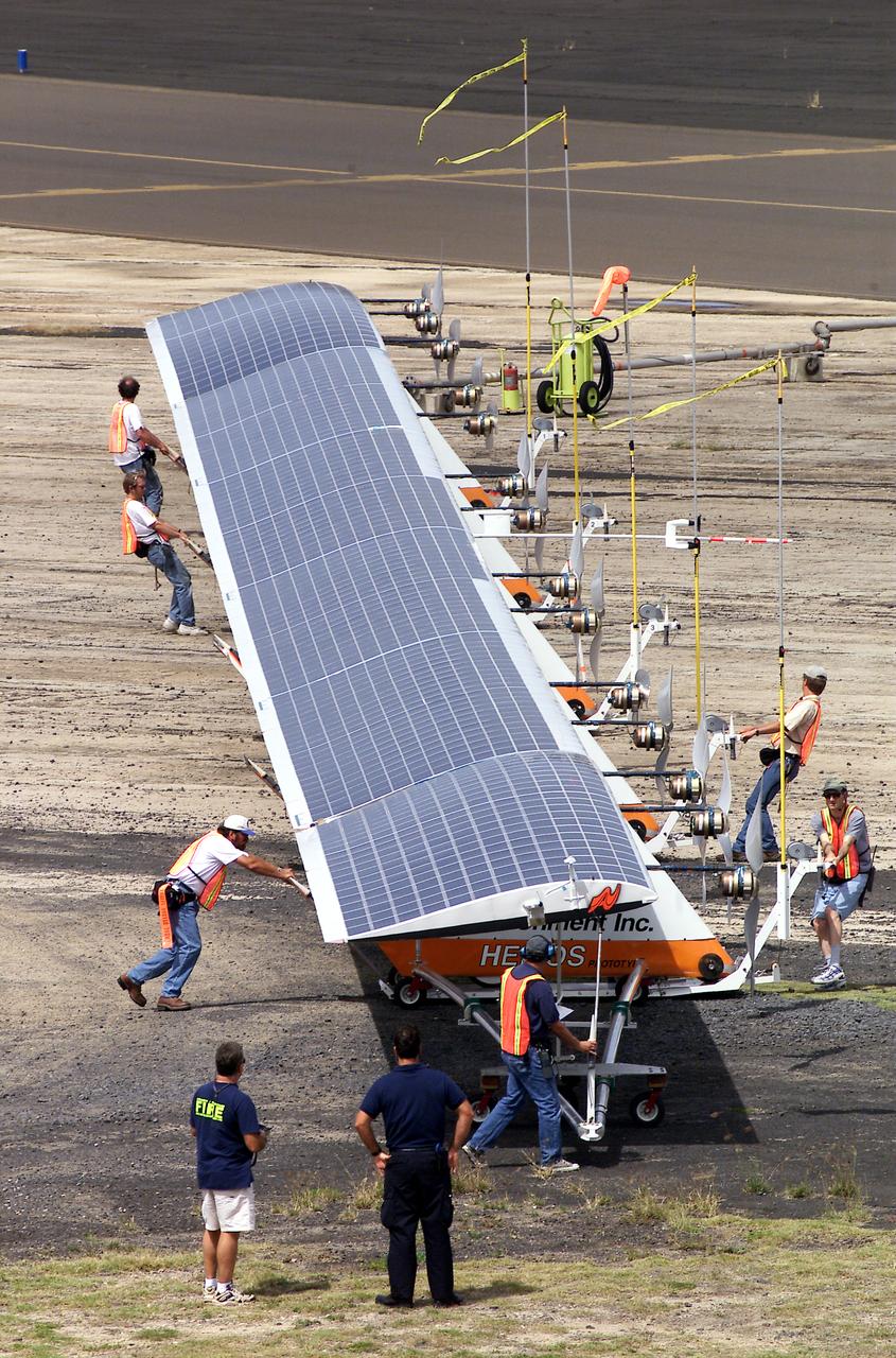 Ground crewmen maneuver AeroVironment's solar-powered Helios Prototype flying wing on its ground support dolly during functional checkouts prior to its first flights under solar power from the U.S. Navy's Pacific Missile Range Facility on Kaua'i, Hawaii.