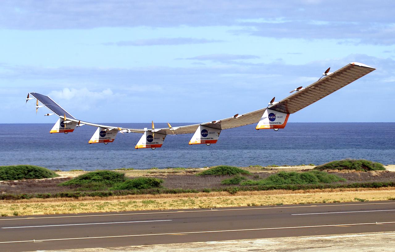 NASA's Helios Prototype aircraft taking off from the Pacific Missile Range Facility, Kauai, Hawaii, for the record flight.  As a follow-on to the Centurion (and earlier Pathfinder and Pathfinder-Plus) aircraft, the solar-powered Helios Prototype is the latest and largest example of a slow-flying ultralight flying wing designed for long-duration, high-altitude Earth science or telecommunications relay missions in the stratosphere. Developed by AeroVironment, Inc., of Monrovia, California, under NASA's Environmental Research Aircraft and Sensor Technology (ERAST) project, the unique craft is intended to demonstrate two key missions: the ability to reach and sustain horizontal flight at 100,000 feet altitude on a single-day flight in 2001, and to maintain flight above 50,000 feet altitude for at least four days in 2003, with the aid of a regenerative fuel cell-based energy storage system now in development. Both of these missions will be powered by electricity derived from non-polluting solar energy.  The Helios Prototype is an enlarged version of the Centurion flying wing, which flew a series of test flights at NASA's Dryden Flight Research Center in late 1998. The craft has a wingspan of 247 feet, 41 feet greater than the Centurion, 2 1/2 times that of its solar-powered Pathfinder flying wing, and longer than the wingspans of either the Boeing 747 jetliner or Lockheed C-5 transport aircraft.  The remotely piloted, electrically powered Helios Prototype went aloft on its maiden low-altitude checkout flight Sept. 8, 1999, over Rogers Dry Lake adjacent to NASA's Dryden Flight Research Center in the Southern California desert. The initial flight series was flown on battery power as a risk-reduction measure. In all, six flights were flown in the Helios Protoype's initial development series.  In upgrading the Centurion to the Helios Prototype configuration, AeroVironment added a sixth wing section and a fifth landing gear pod, among other improvements. The additional wingsp