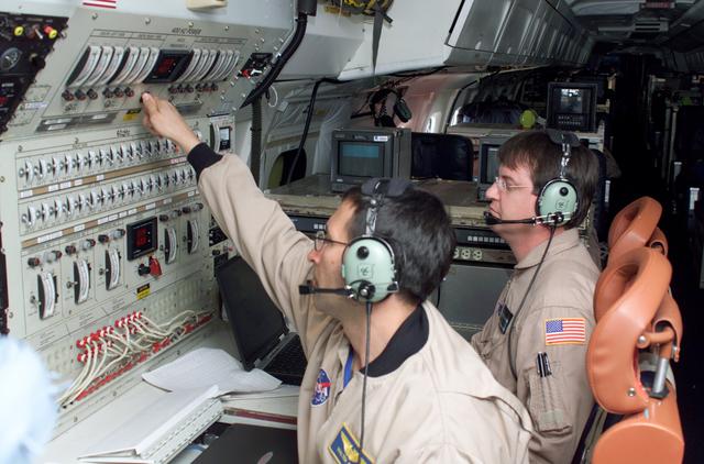 NASA image: Airborne Science personnel Walter Klein and David Bushman at the Mission Manager's console onboard NASA's DC-8 during the AirSAR 2004 campaign