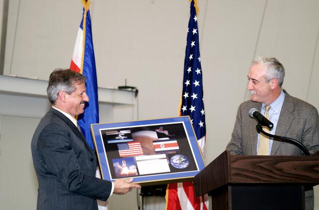 NASA image: NASA Administrator Sean O'Keefe making a presentation to Fernando Gutierrez during the AirSAR 2004 hangar naming ceremony