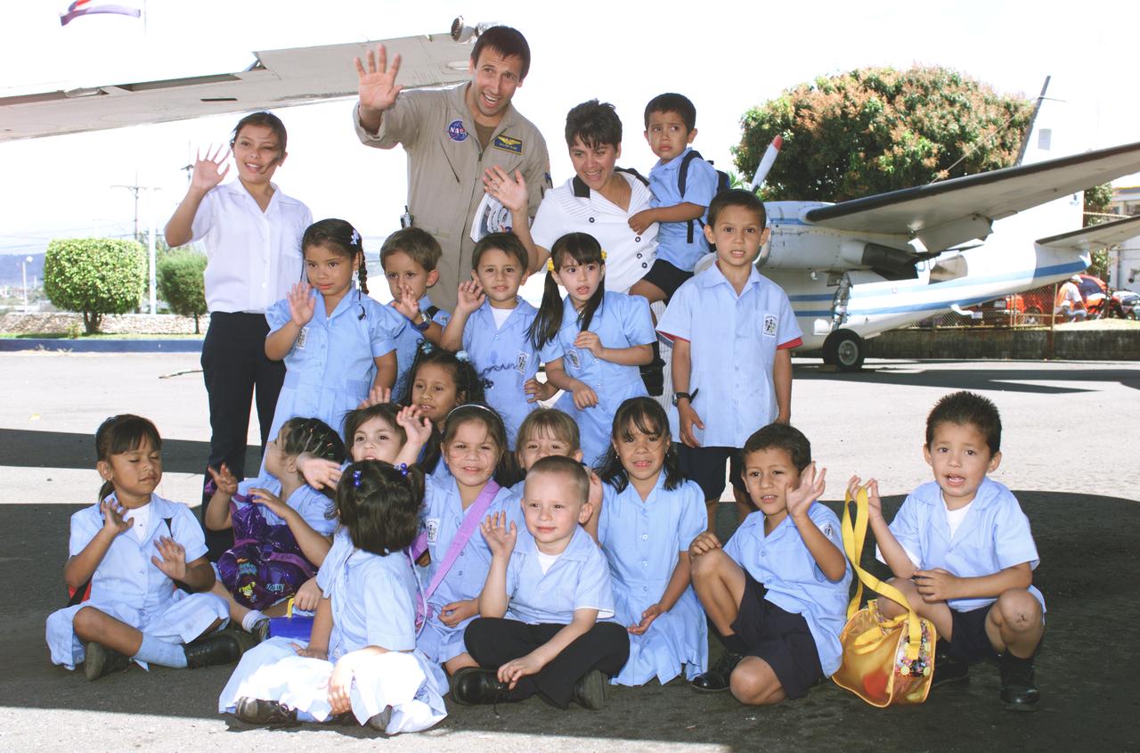 NASA Dryden Mission Manager Walter Klein poses with school children that visited the airport during AirSAR 2004. In spanish, he explained to them the mission of the DC-8 AirSAR 2004 Mesoamerican campaign in Costa Rica. AirSAR 2004 Mesoamerica is a three-week expedition by an international team of scientists that uses an all-weather imaging tool, called the Airborne Synthetic Aperture Radar (AirSAR) which is located onboard NASA's DC-8 airborne laboratory.  Scientists from many parts of the world including NASA's Jet Propulsion Laboratory are combining ground research done in several areas in Central America with NASA's AirSAR technology to improve and expand on the quality of research they are able to conduct.  The radar, developed by NASA's Jet Propulsion Laboratory, can penetrate clouds and also collect data at night. Its high-resolution sensors operate at multiple wavelengths and modes, allowing AirSAR to see beneath treetops, through thin sand, and dry snow pack.  AirSAR's 2004 campaign is a collaboration of many U.S. and Central American institutions and scientists, including NASA; the National Science Foundation; the Smithsonian Institution; National Geographic; Conservation International; the Organization of Tropical Studies; the Central American Commission for Environment and Development; and the Inter-American Development Bank.