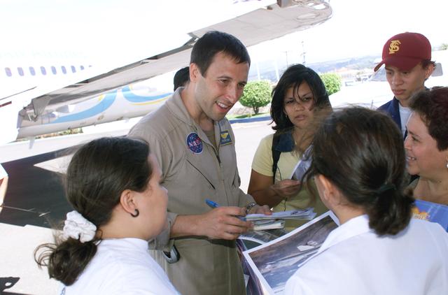 NASA image: DFRC Mission Manager Walter Klein passes out stickers and lithographs to underprivileged Costa Rican school children that visited the airport on Monday March 8, 2004