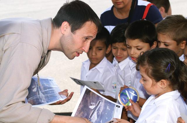 NASA image: DFRC Mission Manager Walter Klein passes out stickers and lithographs to underprivileged Costa Rican school children that visited the airport on Monday March 8, 2004