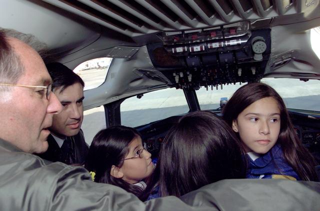 NASA image: Pilot Bill Brockett (left) and Chilean Air Force Captain Saez with school children in the cockpit of NASA Dryden's DC-8 flying laboratory