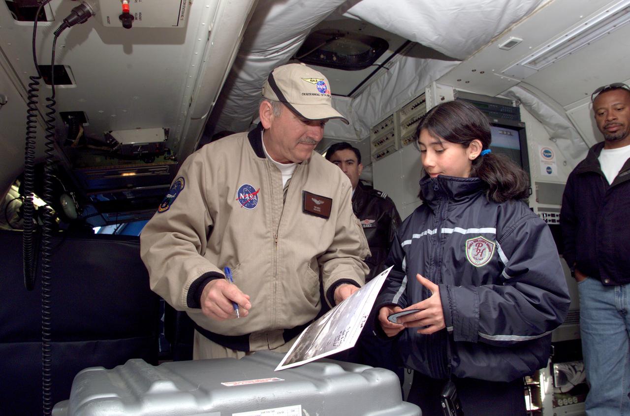 Dr. Tom Mace, NASA DFRC Director of Airborne Sciences, talks with a student from Punta Arenas, Chile, during a tour of the DC-8 aircraft while it was in the country supporting the AirSAR 2004 campaign. AirSAR 2004 is a three-week expedition by an international team of scientists that uses an all-weather imaging tool, called the Airborne Synthetic Aperture Radar (AirSAR) which is located onboard NASA's DC-8 airborne laboratory.  Scientists from many parts of the world including NASA's Jet Propulsion Laboratory are combining ground research done in several areas in Central and South America with NASA's AirSAR technology to improve and expand on the quality of research they are able to conduct.  In South America and Antarctica, AirSAR collected imagery and data to help determine the contribution of Southern Hemisphere glaciers to sea level rise due to climate change. In Patagonia, researchers found this contribution had more than doubled from 1995 to 2000, compared to the previous 25 years. AirSAR data will make it possible to determine whether that trend is continuing or accelerating. AirSAR will also provide reliable information on ice shelf thickness to measure the contribution of the glaciers to sea level.