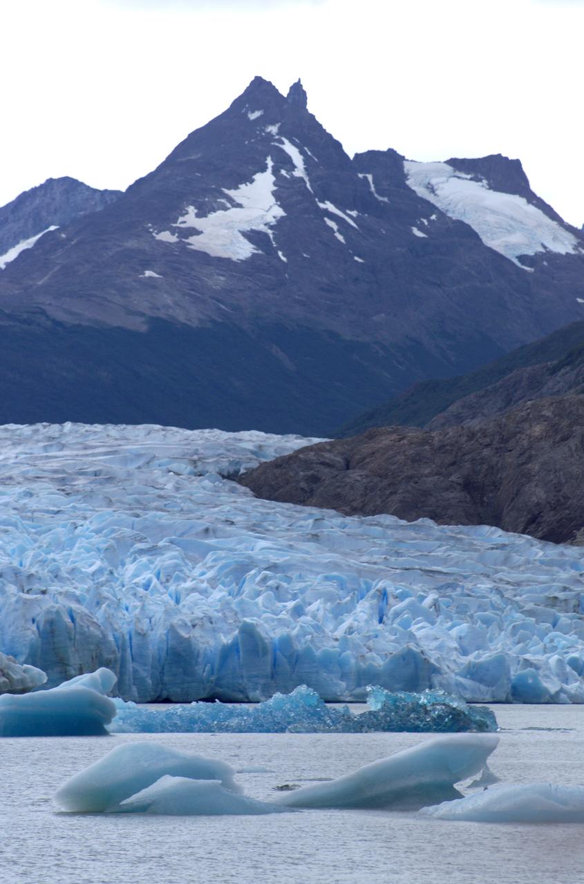 Glacier Grey in front of the Cuernos del Paine mountains, photographed from Lago Grey (Grey Lake) during NASA's AirSAR 2004 campaign in Chile. AirSAR 2004 is a three-week expedition in Central and South America by an international team of scientists that is using an all-weather imaging tool, called the Airborne Synthetic Aperture Radar (AirSAR), located onboard NASA's DC-8 airborne laboratory. Scientists from many parts of the world are combining ground research with NASA's AirSAR technology to improve and expand on the quality of research they are able to conduct. Founded in 1959, Torres del Paine National Park encompasses 450,000 acres in the Patagonia region of Chile. This region is being studied by NASA using a DC-8 equipped with an Airborne Synthetic Aperture Radar (AirSAR) developed by scientists from NASA’s Jet Propulsion Laboratory. This is a very sensitive region that is important to scientists because the temperature has been consistently rising causing a subsequent melting of the region’s glaciers. AirSAR will provide a baseline model and unprecedented mapping of the region. This data will make it possible to determine whether the warming trend is slowing, continuing or accelerating. AirSAR will also provide reliable information on ice shelf thickness to measure the contribution of the glaciers to sea level.