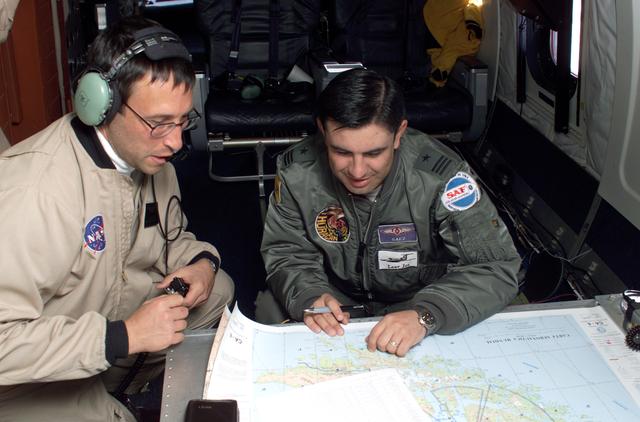 NASA image: NASA DC-8 Mission Manager Walter Klein and Chilean Air Force Advisor Captain Saez review maps of the Antarctic Peninsula during an AirSAR 2004 mission